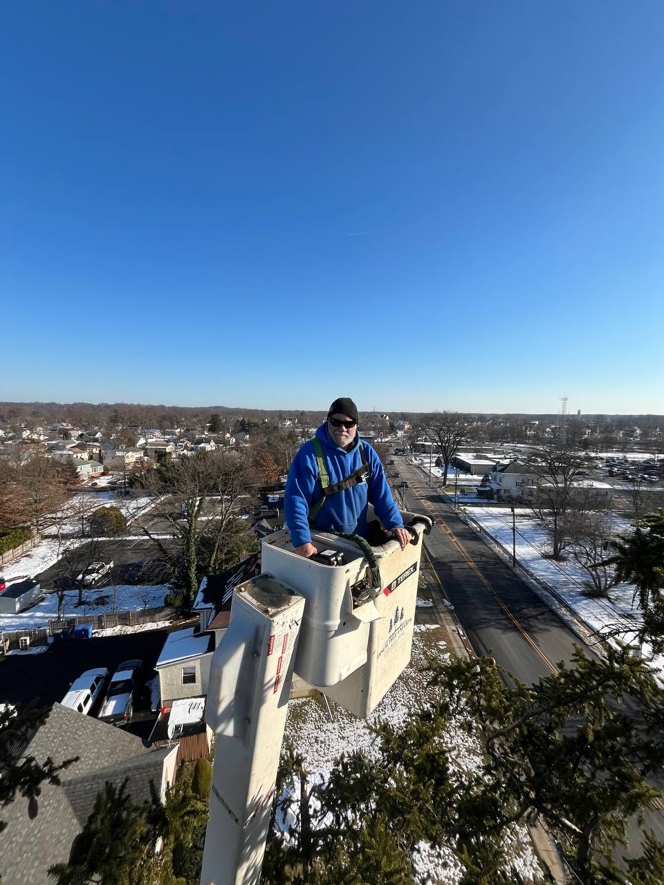 Disch crew member up in the bucket overlooking a snow-dusted Central NJ neighborhood